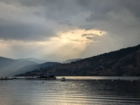Sun rays breaking through over the lake, Okanagan Lake at Okanagan Landing, Vernon, B.C., August 26, 2024
